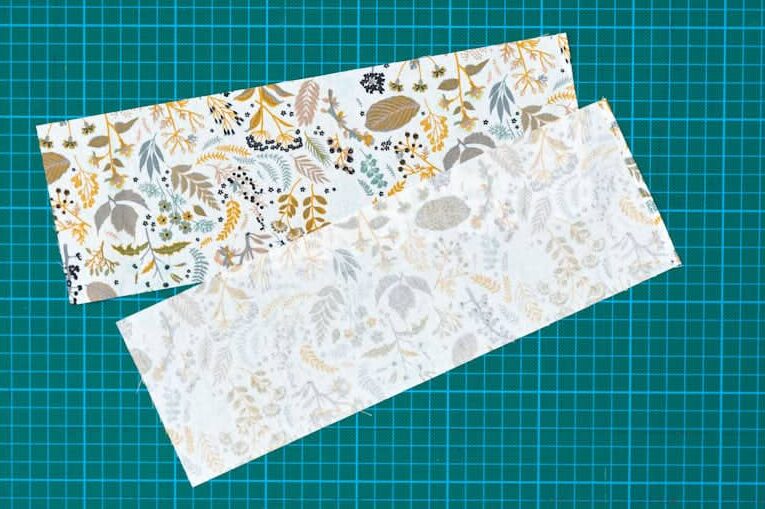 two rectangular pieces of fabric on green cutting mat