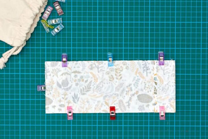 fabric clipped together with a bag of clips on the side on top of green cutting mat