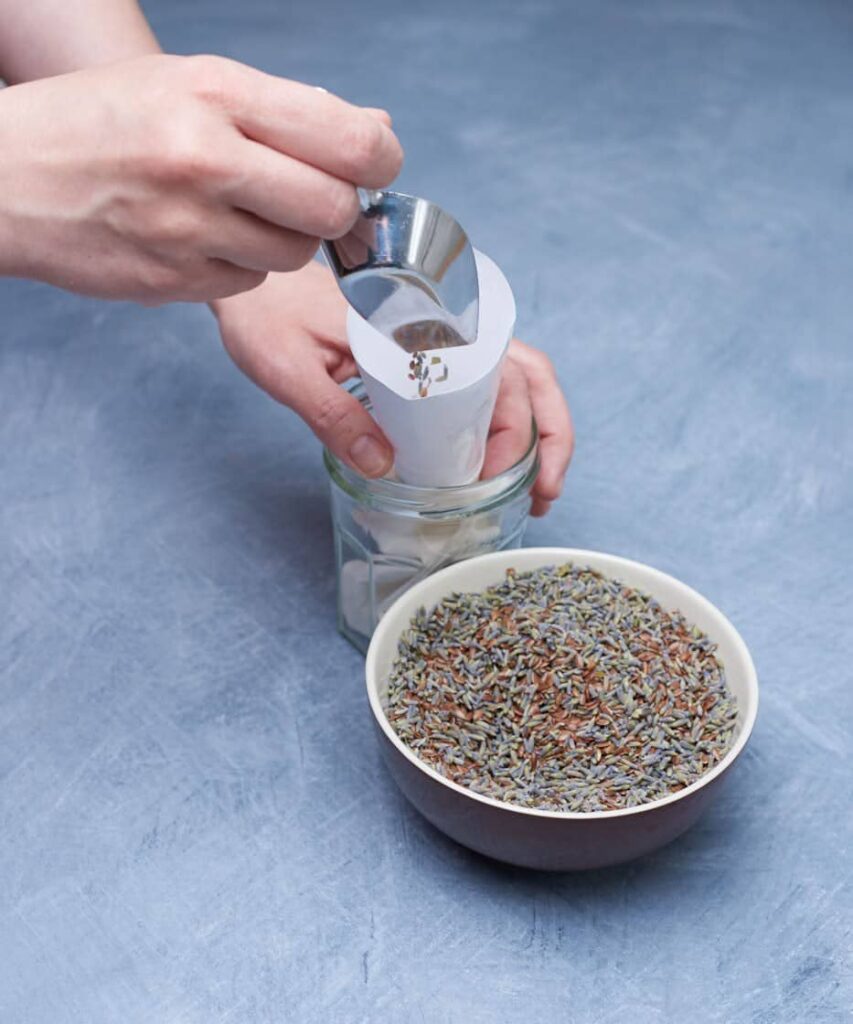 Filling an eyepillow with a mixture of flaxseed and dried lavender