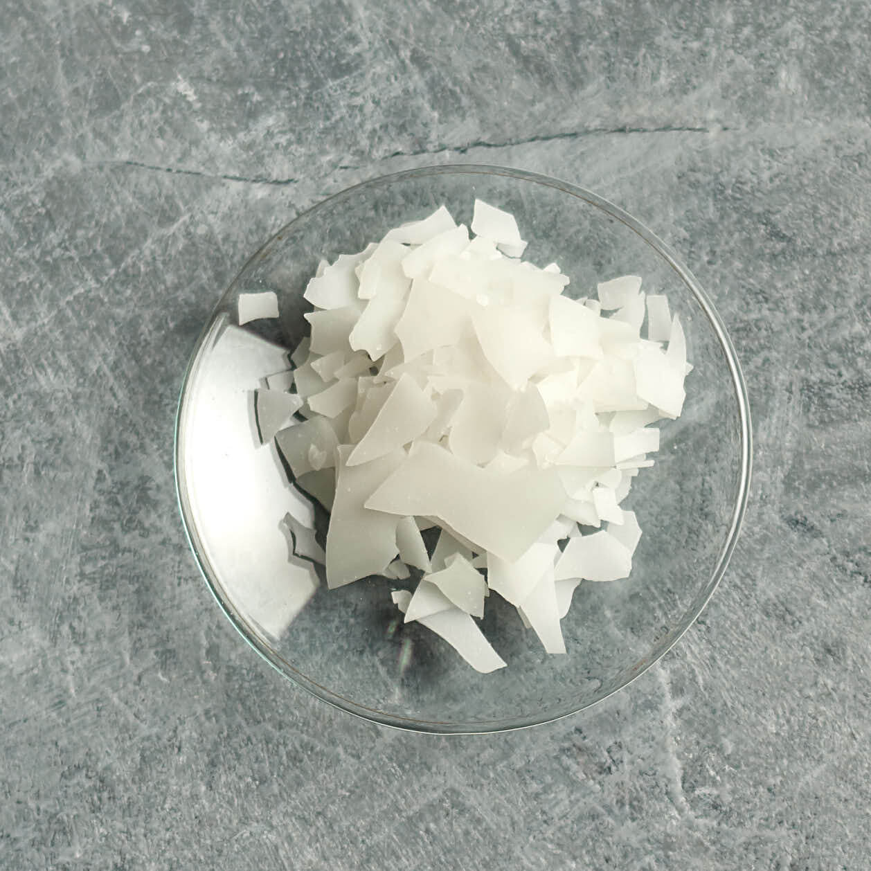 Olivem1000 flakes on a small glas dish